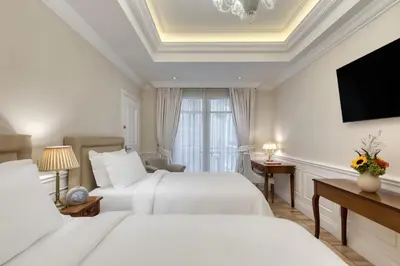 a hotel room with two beds and a television at King George, a Luxury Collection Hotel, Athens in Athens