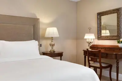 a bedroom with a bed and a desk and a mirror at King George, a Luxury Collection Hotel, Athens in Athens