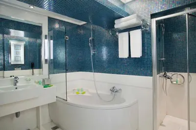 a bathroom with a tub and a sink and a shower at Crowne Plaza Athens City Centre by IHG in Athens