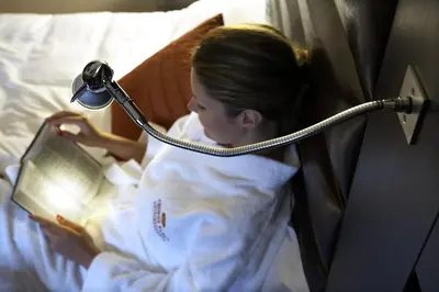 a young girl laying in bed reading a book at Crowne Plaza Athens City Centre by IHG in Athens
