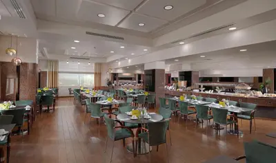 a restaurant with tables and chairs and a bar at Holiday Inn Athens Attica Av, Airport W. by IHG in Athens
