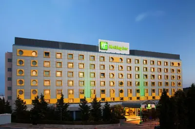 a hotel building with a sign on top of it at Holiday Inn Athens Attica Av, Airport W. by IHG in Athens