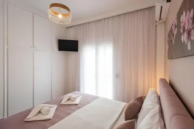 a bedroom with a bed and a couch and a window at Blue Ark Boho Stay at Acropolis in Athens