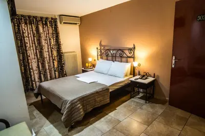 a bedroom with a bed and a nightstand and a bed sidx sidx sidx sidx at Anita Hotel in Piraeus