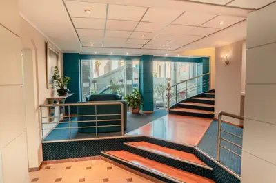 a lobby of a building with stairs and blue walls at Anita Hotel in Piraeus