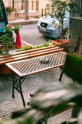 a bench on a street with a car in the background at Anita Hotel in Piraeus