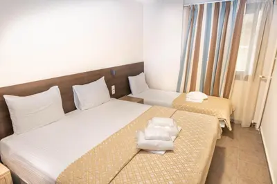 a hotel room with two beds with towels on them at Anita Hotel in Piraeus