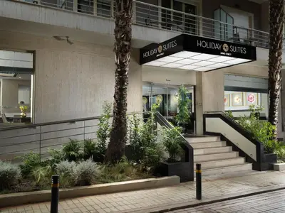 a lobby of a building with stairs and plants at Holiday Suites in Athens