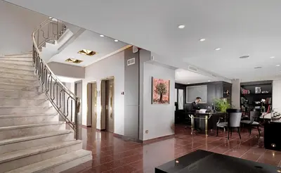 a staircase in a house with a man sitting at a table at Holiday Suites in Athens