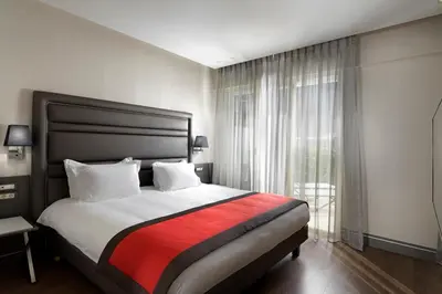 a bedroom with a large bed and a window at Holiday Suites in Athens