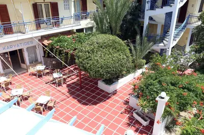 an overhead view of a courtyard with tables and plants at Hotel Karyatides in Agia Marina Aegina