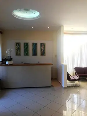 a lobby with a waiting area with a circular ceiling at Hotel Karyatides in Agia Marina Aegina