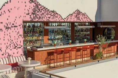 a rendering of a bar with a pink wall at Ace Hotel & Swim Club Athens in Athens