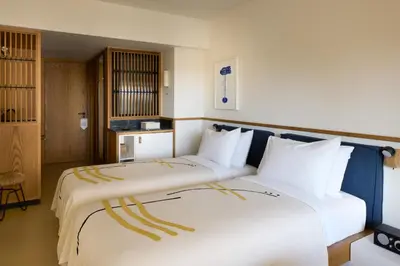 a hotel room with two beds with white pillows at Ace Hotel & Swim Club Athens in Athens