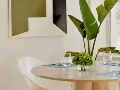 a table with two glasses and a plant on it at The Roc Club, A Grecotel Hotel to Live in Athens