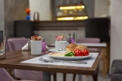 a table with a plate of food on a table at Pan Hotel in Athens