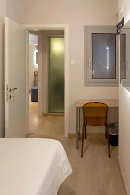 a bedroom with a bed and a table and a chair at Pan Hotel in Athens
