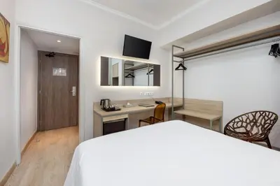 a bedroom with a white bed and a desk with a computer at Pan Hotel in Athens