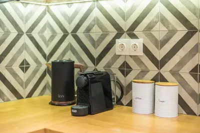 a coffee maker sitting on a table next to cups at Pame Rentals - Walk Distance To Acropolis with A Charming Design in Athens