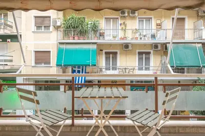 a table and chairs on a balcony with a building at Pame Rentals - Walk Distance To Acropolis with A Charming Design in Athens