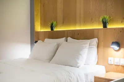 a bed with white pillows and potted plants on it at Pame Rentals - Walk Distance To Acropolis with A Charming Design in Athens
