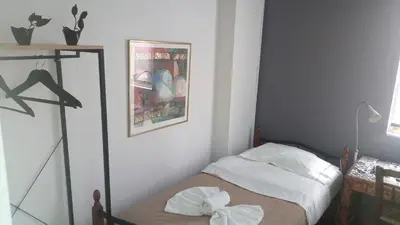 a small bedroom with a small bed with white sheets at WineSpa Oasis in Athens ! in Athens
