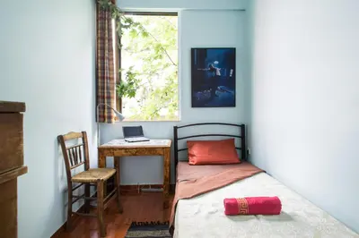 a bedroom with a bed and a desk and a window at WineSpa Oasis in Athens ! in Athens