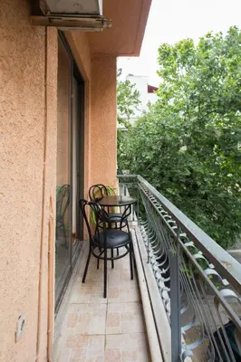 a patio with two chairs and a table on a balcony at WineSpa Oasis in Athens ! in Athens
