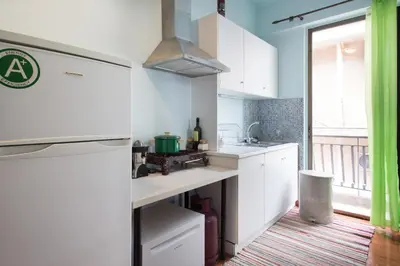 a kitchen with white cabinets and a large window at WineSpa Oasis in Athens ! in Athens