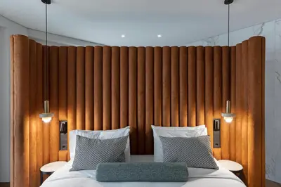 a bed in a room with a wooden wall at The Stanley in Athens