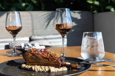 a steak on a plate with two glasses of wine at The Stanley in Athens