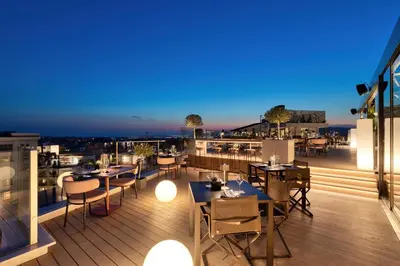 a restaurant with tables and chairs on a balcony at The Stanley in Athens