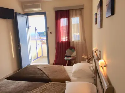 a bedroom with a bed and a sliding glass door at Isidora Hotel in Agia Marina Aegina
