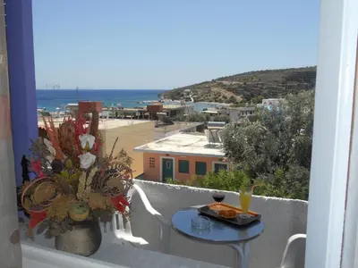 a balcony with a table and a view of the ocean at Isidora Hotel in Agia Marina Aegina