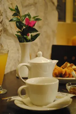 a table with a cup of tea and a plate of pastries at Hotel Ideal in Piraeus