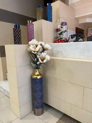 a blue vase with white flowers in it at Hotel Ideal in Piraeus