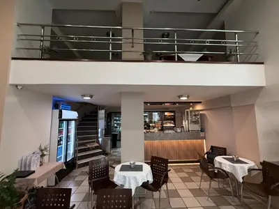 a restaurant with tables and chairs and a balcony at Glaros Hotel in Piraeus