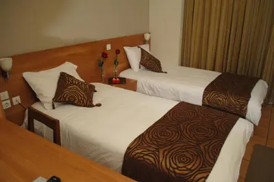 a hotel room with two beds and flowers in it at Glaros Hotel in Piraeus