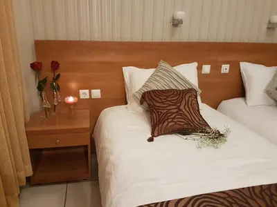 a hotel room with two beds with roses on the bed at Glaros Hotel in Piraeus