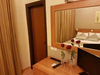 a bedroom with a bed and a large mirror at Glaros Hotel in Piraeus