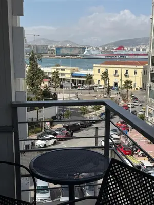 a balcony with a table and a view of a parking lot at Glaros Hotel in Piraeus