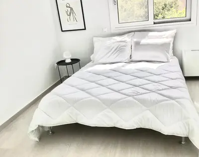 a bedroom with a white bed with a white comforter at ATHENS RIVIERA Grand Panoramic Villa II Lagonissi in Lagonissi