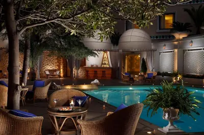 a resort with a pool and chairs and a table at Royal Olympic Hotel in Athens