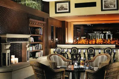 a restaurant with a table and chairs and a fireplace at Royal Olympic Hotel in Athens