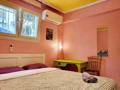 a bedroom with a bed and a desk and a window at Sakura Hut opposite the Panathenaic Stadium in Athens