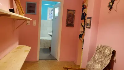 a bathroom with pink walls and a sink and a table at Sakura Hut opposite the Panathenaic Stadium in Athens
