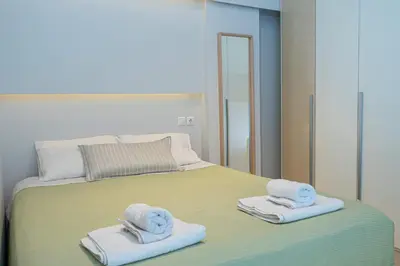 a bedroom with a bed with towels and a mirror at Nikkis Flat - Kolonaki Square in Athens