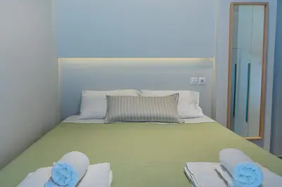 a bedroom with a bed with two towels and a mirror at Nikkis Flat - Kolonaki Square in Athens