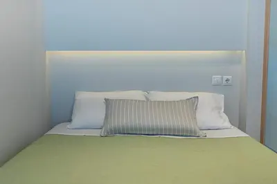 a bed with white pillows and a green blanket at Nikkis Flat - Kolonaki Square in Athens