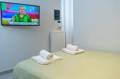 a room with a bed with a tv on the wall at Nikkis Flat - Kolonaki Square in Athens